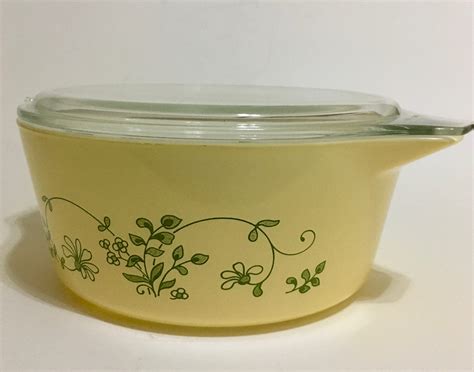 "Hex Signs" 475 Cinderella casserole in white with turquoise pattern, patterned clear lid and patterned underplate "Sunflower" pattern in orange-yellow on 473. . Pyrex 475